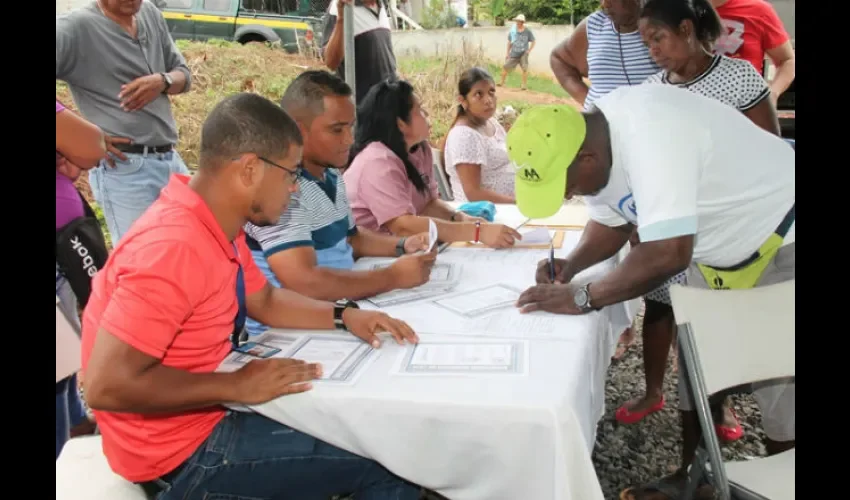 Foto ilustrativa de las personas recibiendo los títulos de propiedad. 