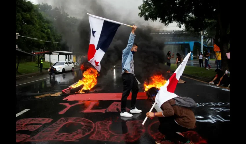  Estudiantes de la Universidad de Panamá (UP) realizan grafitis hoy sobre la vía Transístmica durante una protesta contra los recortes presupuestarios a su institución, en Ciudad de Panamá (Panamá). La Universidad de Panamá solicitó para el 2021 un presupuesto de 385 millones de dólares, pero el Ministerio de Economía le hizo un recorte de 91 millones de dólares, lo que ha generado protestas estudiantiles. EFE/Bienvenido Velasco.