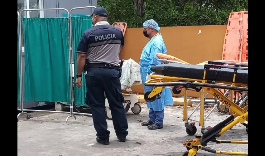 Unidad de la Policía Nacional junto a personal de salud que recibe a los pacientes en el hospital. 